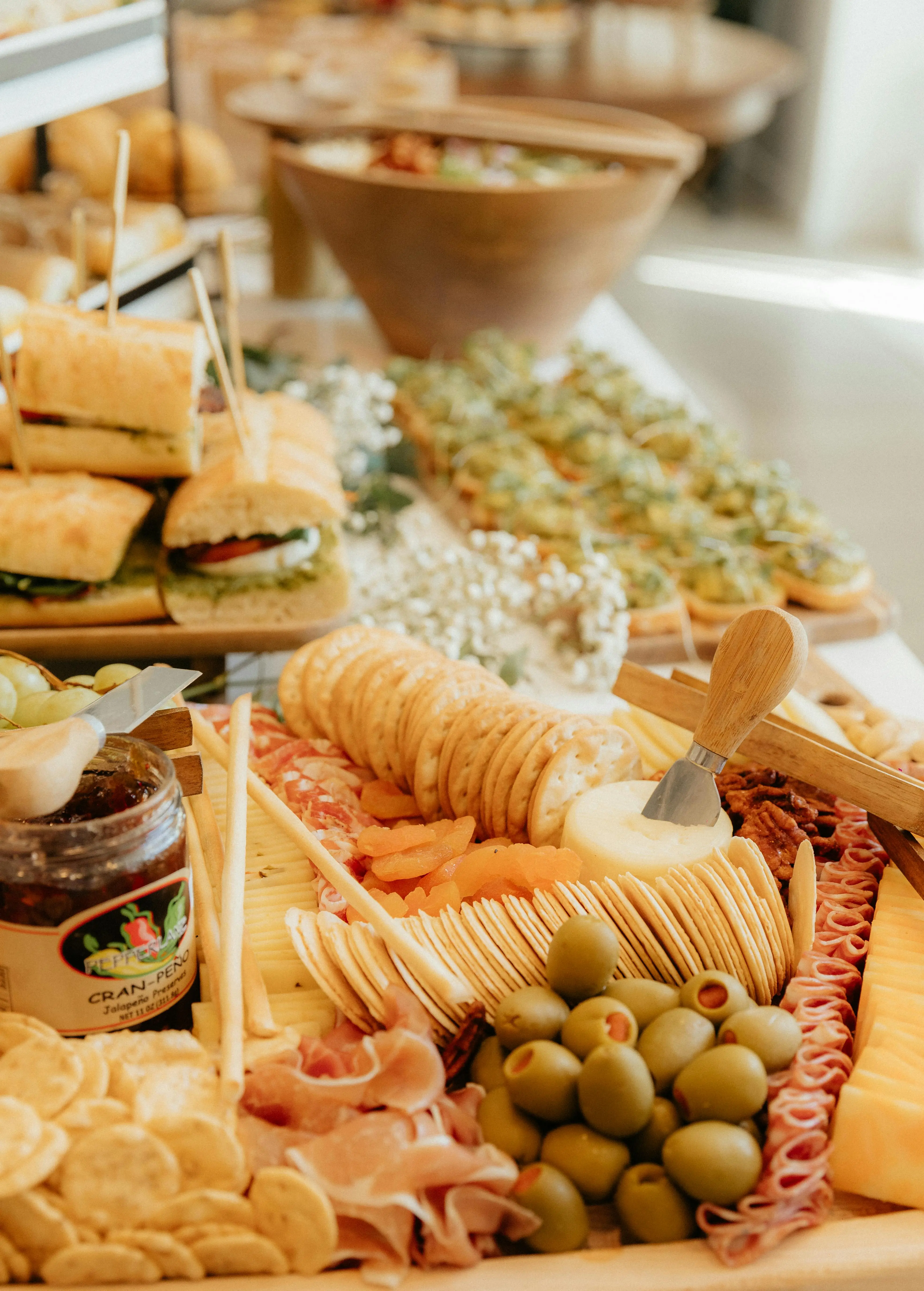 Full aesthetic grazing table spread with crackers, olives, salami and jam for entertaining