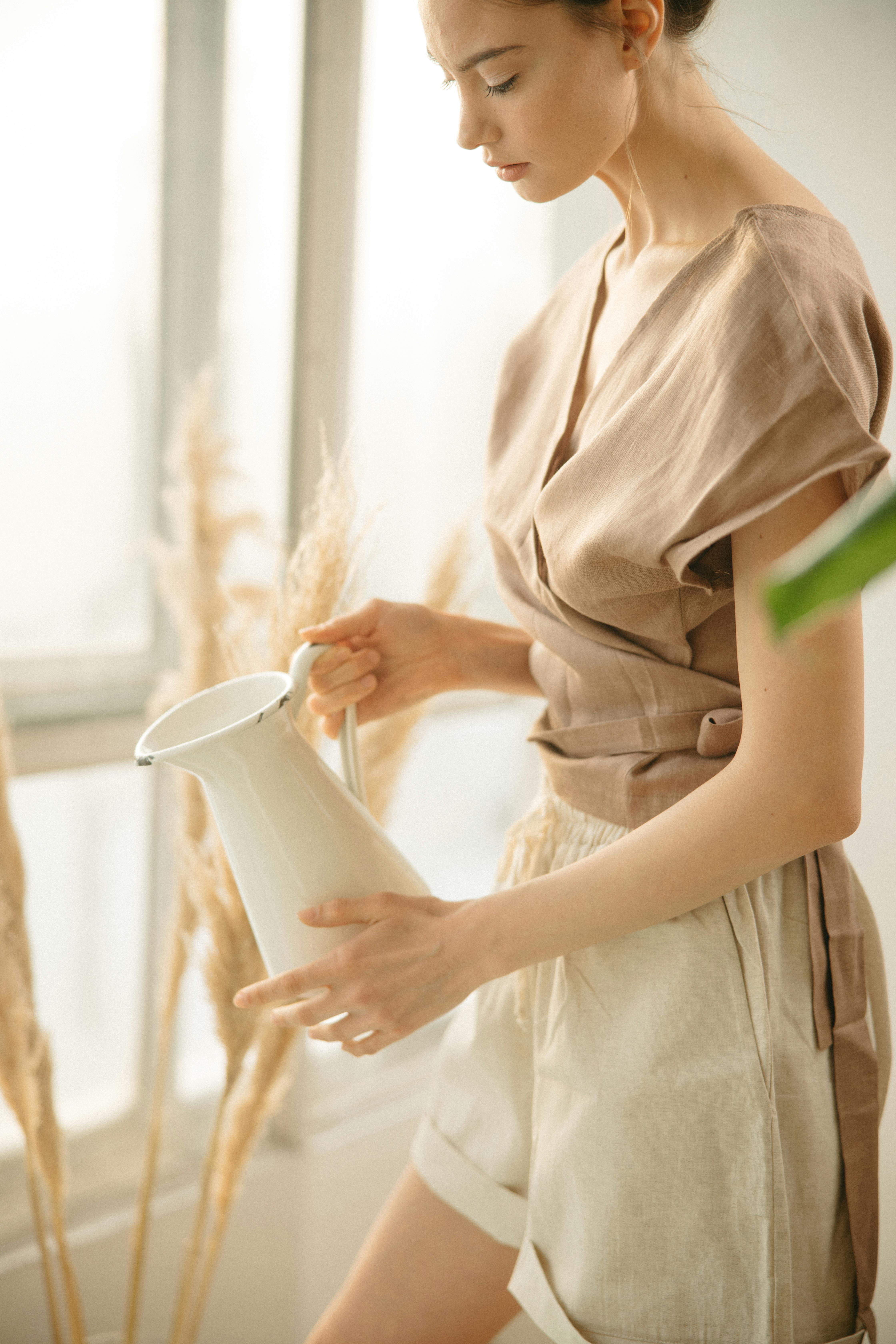 Boho maximalism summer 2026 — woman in linen wrap top and shorts with pampas grass