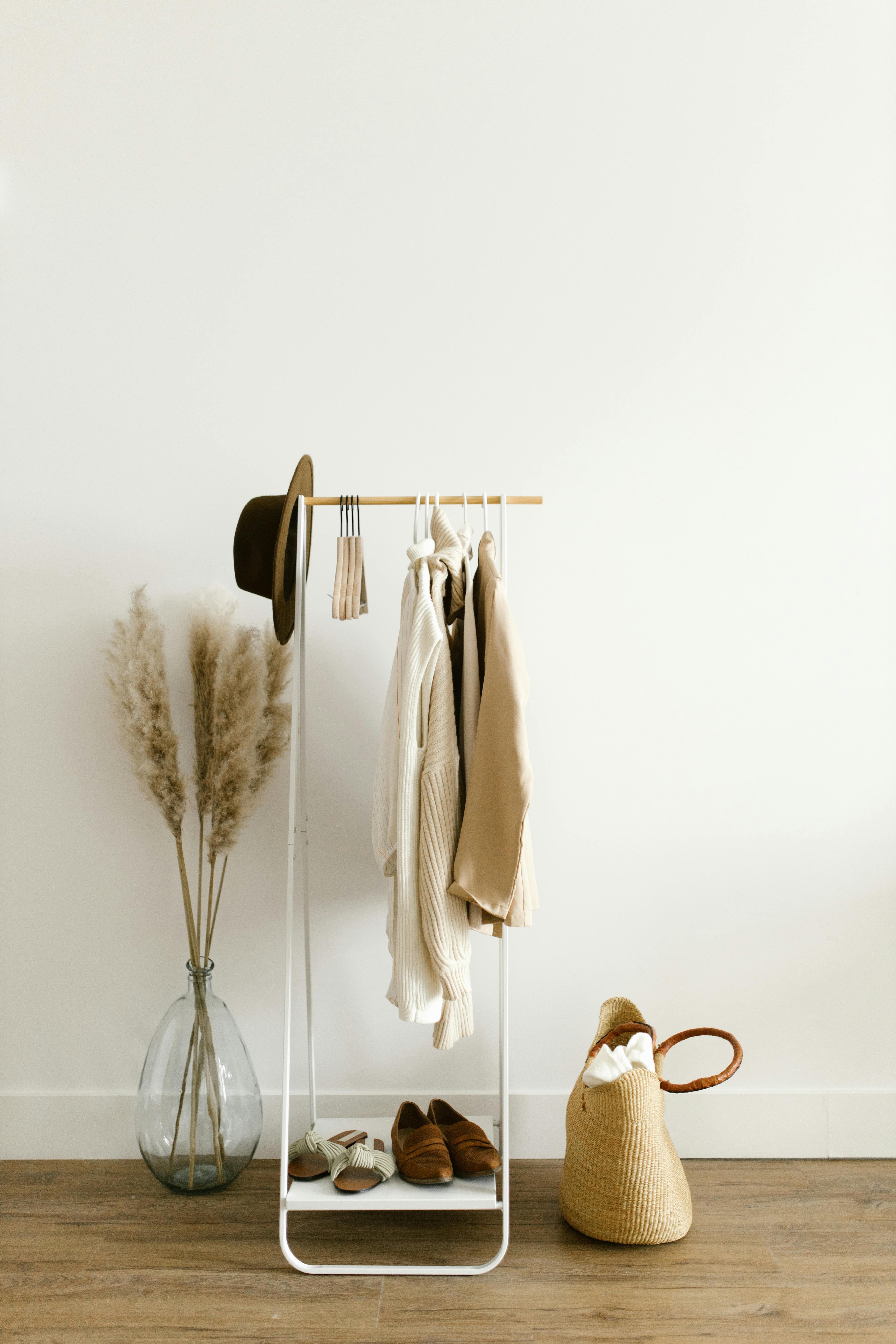 Organized capsule wardrobe closet with neutral clothes and nude heels on shelves