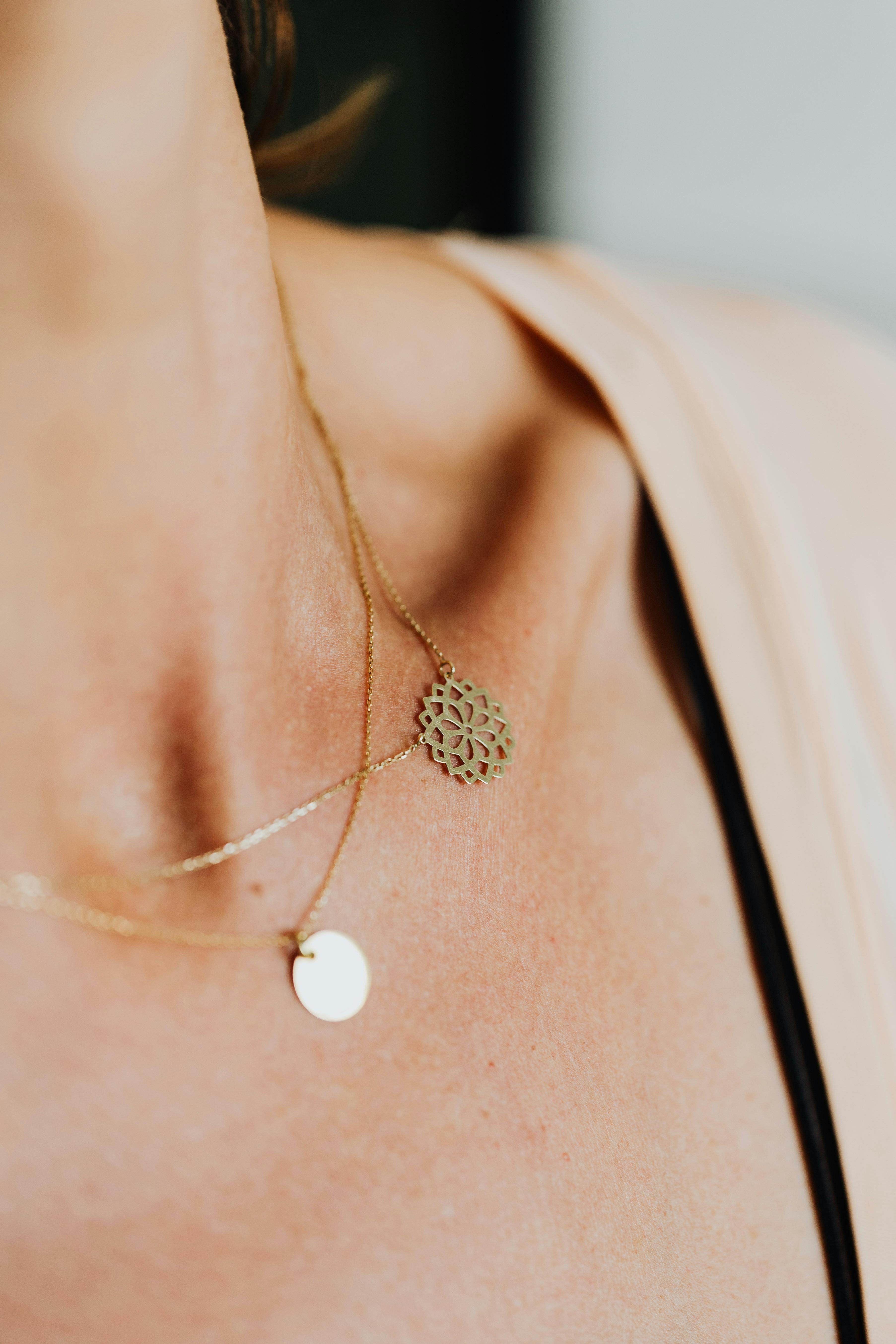 Statement jewelry trend 2026 — layered gold necklaces close up warm natural light