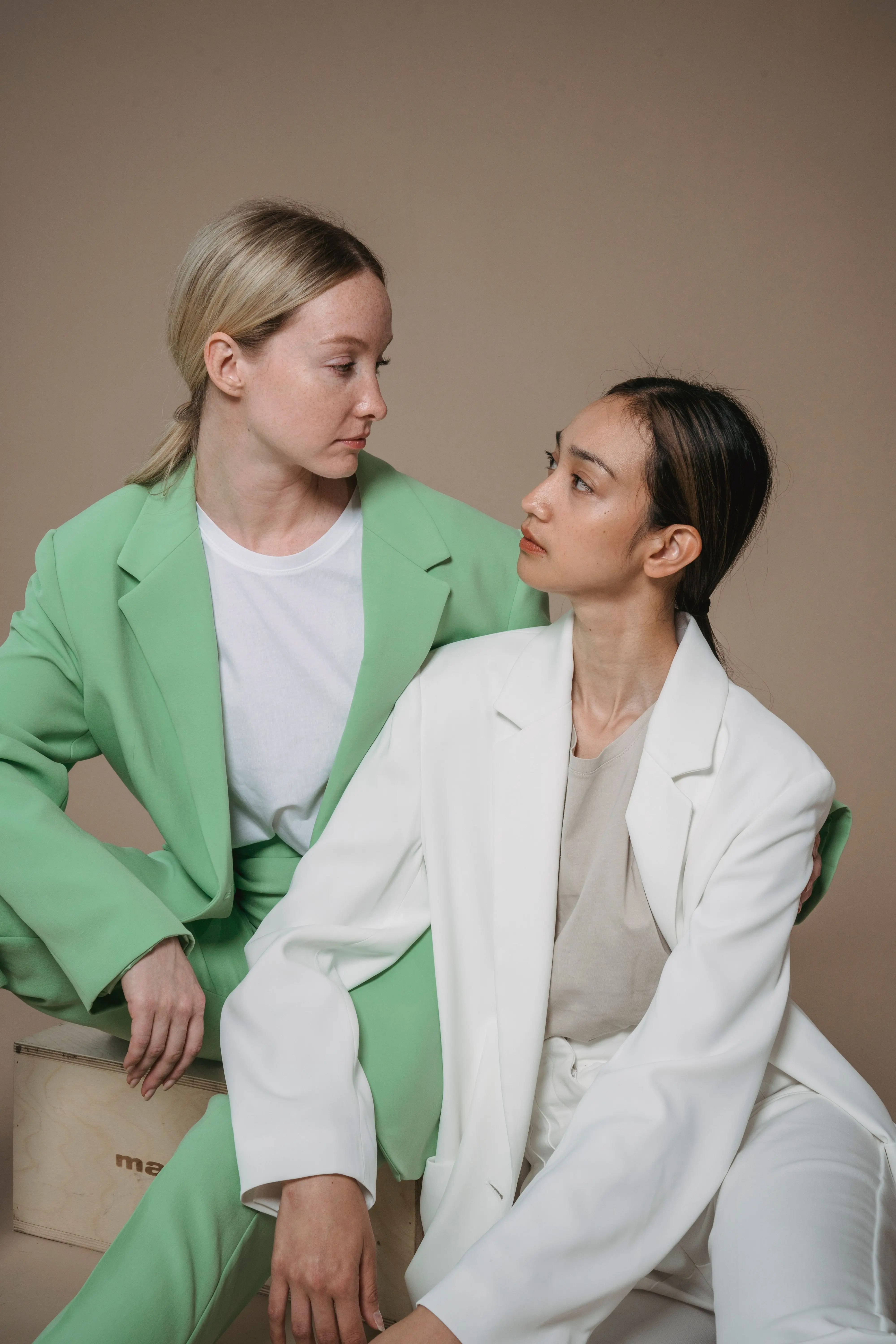Transformative teal color of the year 2026 — women in structured blazers sage and white